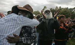 An Aboriginal elder embraces a younger man after Kevin Rudd delivers a formal apology to members of the Stolen Generation.