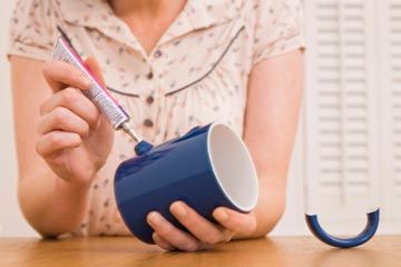 Woman gluing broken mug