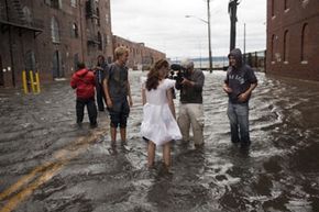 Journalists interview Betty Walsh (C), a local resident of Brooklyn, N.Y. during Hurricane Irene. See more storm pictures.
