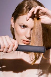 Woman using straight-iron on her hair