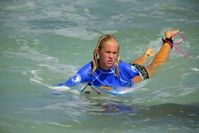 A shark's bite was strong enough to take Bethany Hamilton's arm while she was surfing at age 13. Hamilton (shown here in 2005) continued to surf competitively after recovering from her attack. See pictures of sharks.