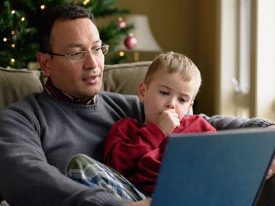 father reading to child who is sucking his thumb