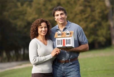 couple holding model house