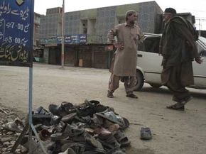 Residents of Dera Ismail Khan, Pakistan, walk past the slippers of those killed and injured in the Feb. 20, 2009, suicide bombing of a Shiite funeral procession.