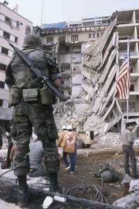 A U.S. Marine stands guard as rescue workers search the rubble of the U.S. embassy in Beirut for bodies following the 1983 suicide attack.