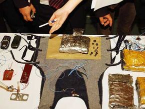 Uzbek officials display confiscated homemade bombs, guns and suicide vest