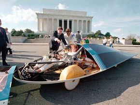 Energy Secretary John Herrington, left, points to a component of the solar-powered GM Sunraycer while co-driver Molly Brennan of Waterford, Mich., sits in the cockpit in Washington, D.C., Nov. 18, 1987.
