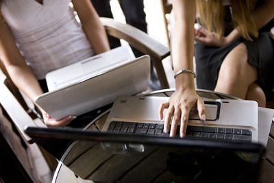 Women using laptops outdoors.