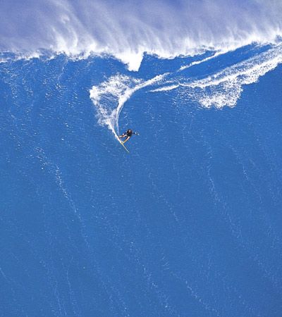 A man tow-surfing a big wave in Hawaii.