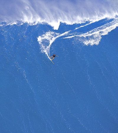 一个男人tow-surfing在夏威夷一个大浪。”border=