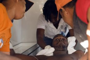 This gentleman was one of only two survivors of a boat where 49 people died after drifting more than three weeks at sea. He is helped by civil workers for transport to a Santo Domingo hospital in the Dominican Republic on Dec. 5, 2008.