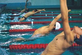 这些游泳运动员在泳道练习，以锻炼他们的姿势和成绩。＂width=