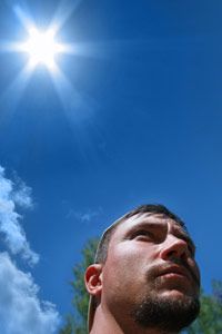 Man with sun beating down in background.