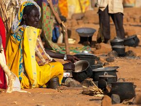 The harsh environmental conditions of the Sahel contribute to the region's strife: A woman who fled fighting prepares tea at a shelter in North Darfur, Sudan.