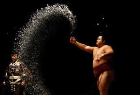 Sumo wrestler Chiyotaiki purifies the ring with salt at the Grand Sumo Championship.
