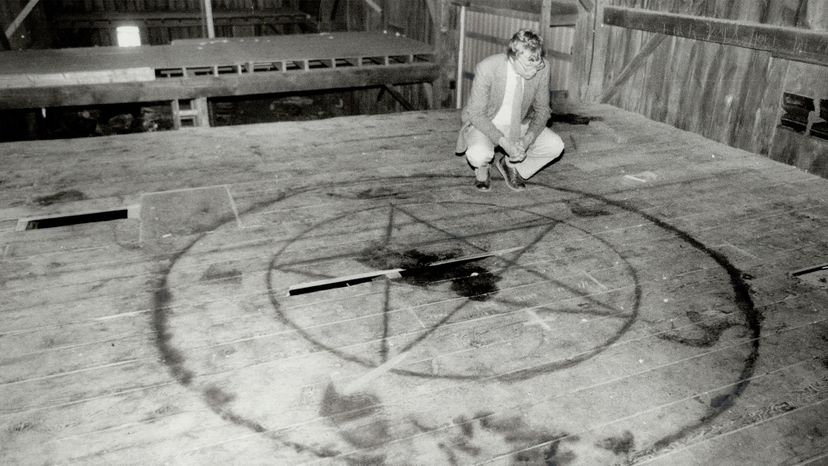 A Star reporter examines a pentagram painted on the floor of a barn loft, 1964, after rumors of a Satanic cult erupted in an Ontario town. Reg Innell/Toronto Star via Getty Images