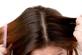 Woman parting and combing hair.