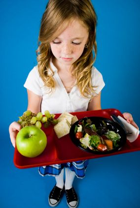 Young school girl studying her healthy lunch