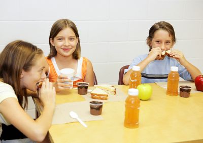A group of school children having lunch in the school cafeteria.