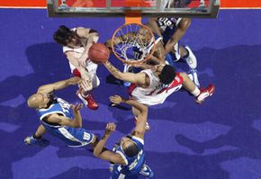Mark Jones of the University of Dayton Flyers rebounds the ball amidst the defense of the University of Tulsa Golden Hurricanes during the first round of the NCAA Tournament on March 20, 2003, in Spokane, Wash.