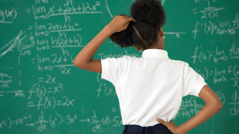 girl scratching head at blackboard