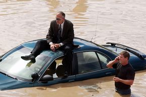 Castle Rock Police Department investigator Tim Gorman sits on top of his flooded-out police car waiting for Denver firefighters to rescue him from a highway just after a major rainstorm in 2002.