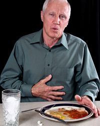 man with empty plate and antacid
