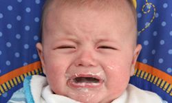 crying baby with spit-up on face