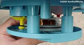 The yellow governor can be seen inside a cylinder molded into the blue plastic.