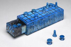 A bright blue Senet board with a pull-out tray and several playing pieces.