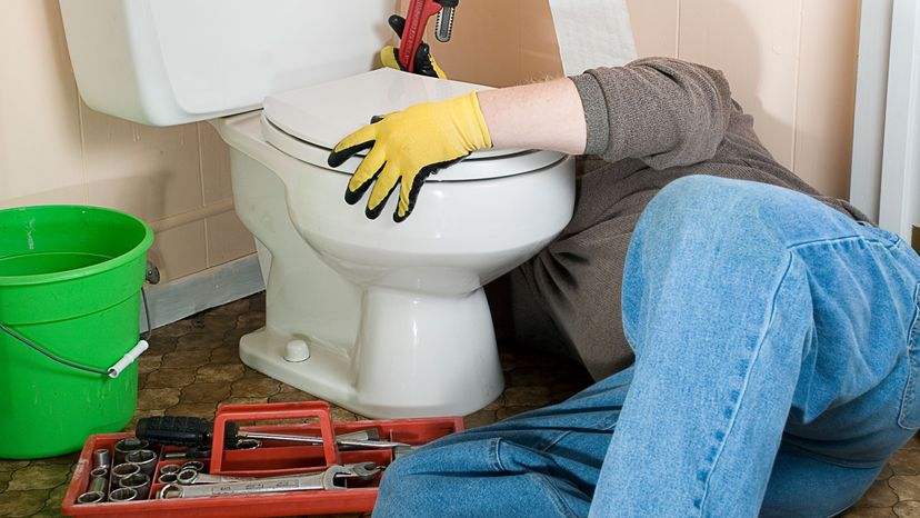 man repairing toilet