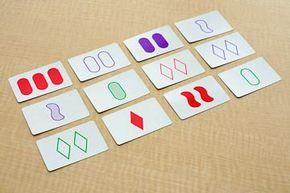 The cards in the rightmost column are not a SET because two are single-symbol cards and one is not; the cards in the leftmost column are a SET because each variable is different. Can you find the other five SETs in this puzzle?