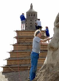 German sculptors work on a sand replica of the pharos during a sand sculpting competition