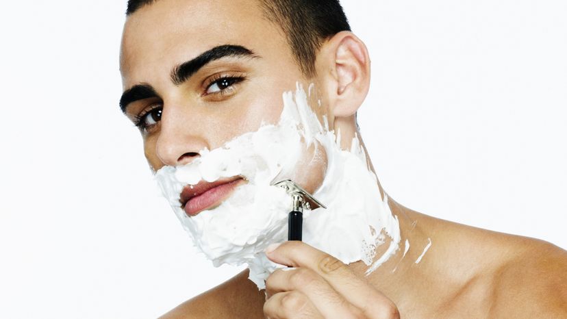 A man shaving his face.