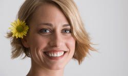 woman with short hair and flower tucked behind ear