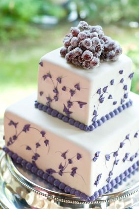 short purple and white wedding cake decorated with grapes