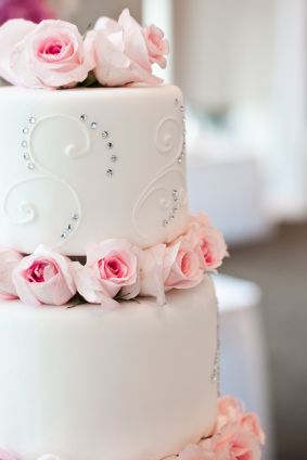 white wedding cake with pink roses and faux diamonds