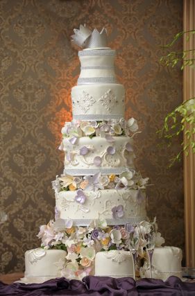 tall five-tiered wedding cake with crown topper