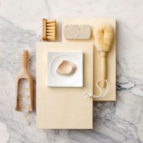 Various exfoliant items photographed from overhead on a marble surface.