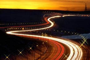 Light trails of cars on a highway at night.