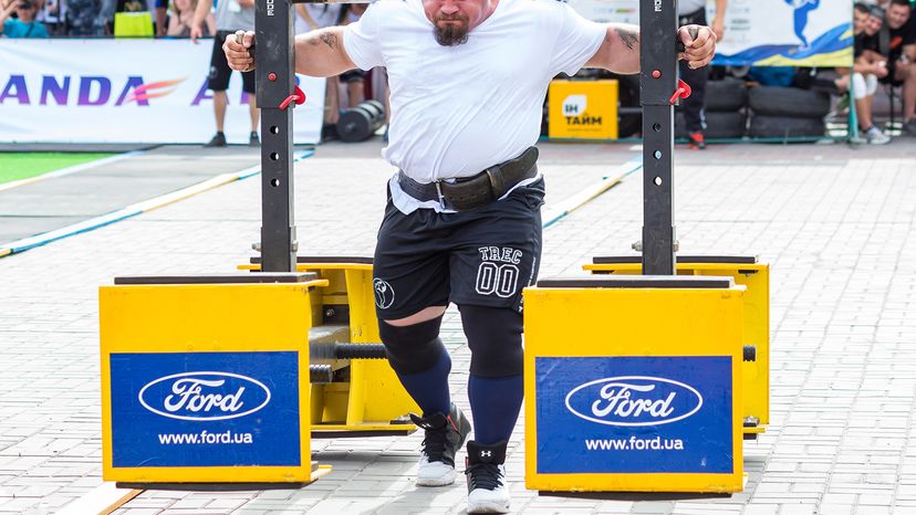 Man with weight belt carrying a heavy yoke