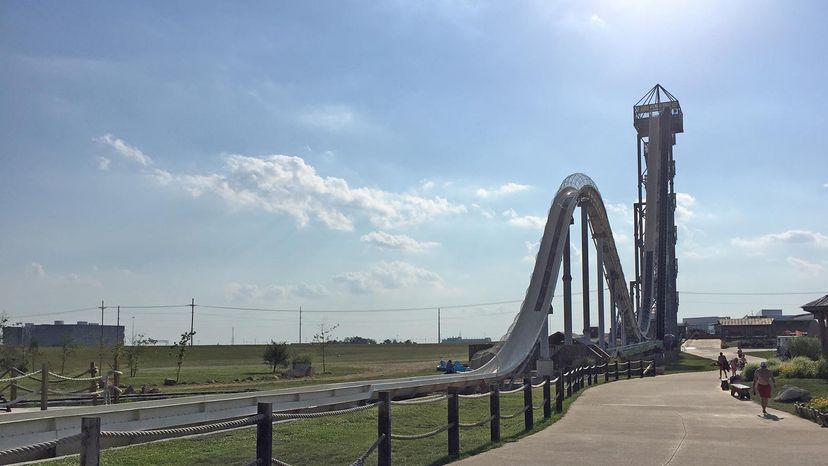 People walking by the world's tallest waterslide on a sunny day
