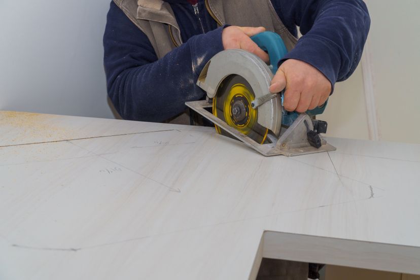 Carpenter using a saw to cut laminate counter top.&nbsp;