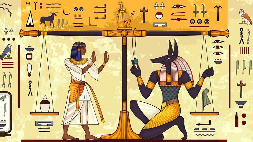 hieroglyphic illustration of Anubis weighing an urn and a feather on a scale