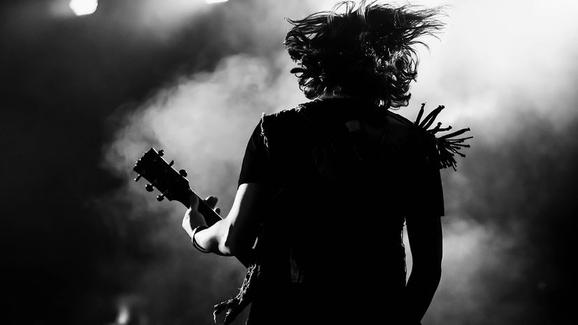 A guitar player making rock music during concert