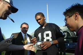Former Oakland Raiders wide receiver Randy Moss greets fans after his 2005 introductory press conference. The team restructured his salary to include a prorated signing bonus spread out over the length of his contract.