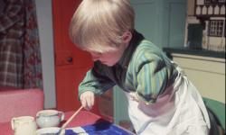 A Thalidomide child painting at home.