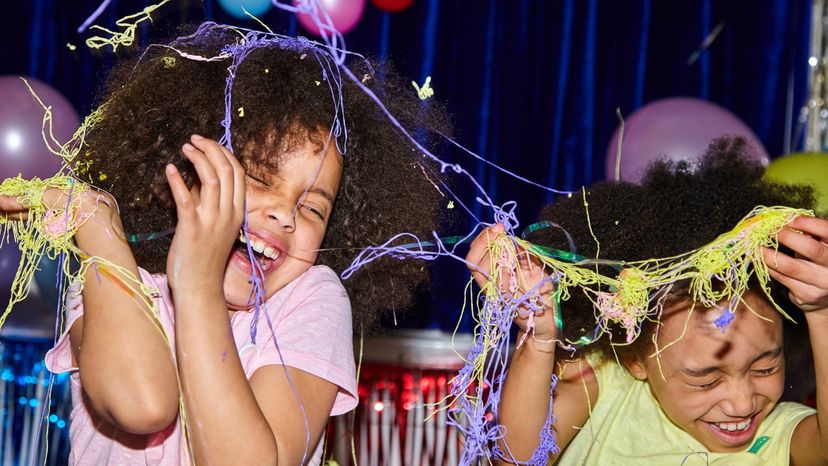 Young girls having fun together at a birthday party celebration with silly strings