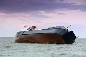 Ship sails on industrial nautical vessel in water.