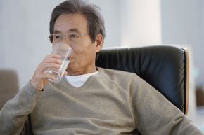 man drinking a glass of water